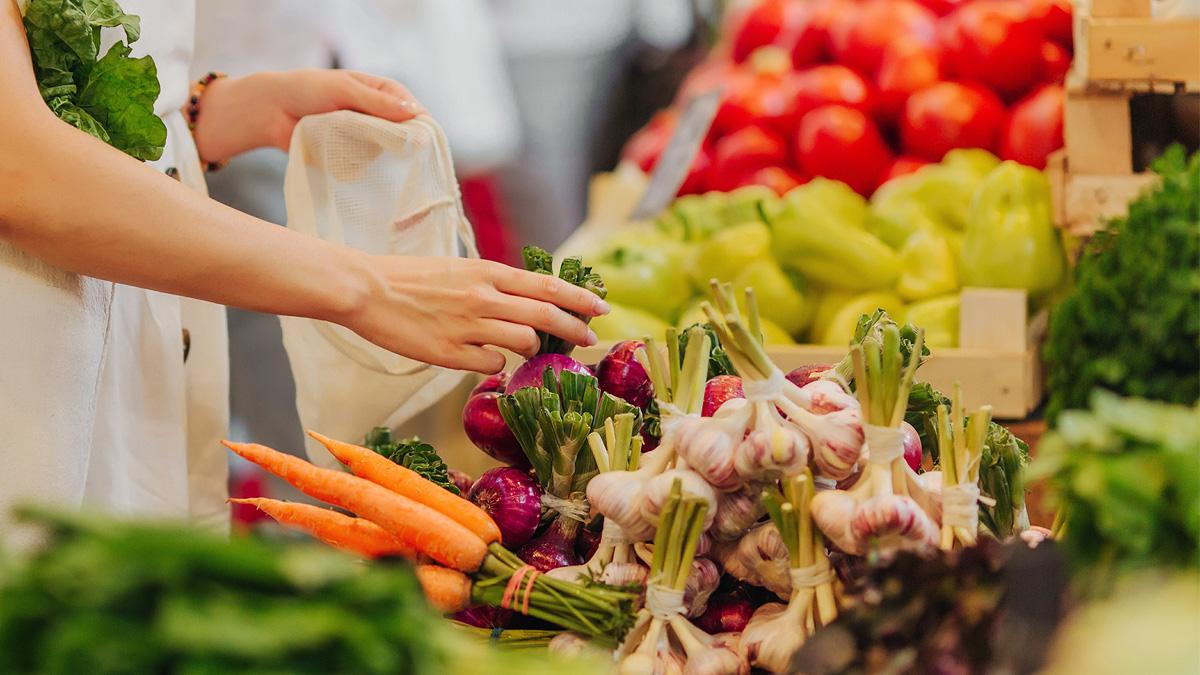 Woman picking up produce at the grocery store